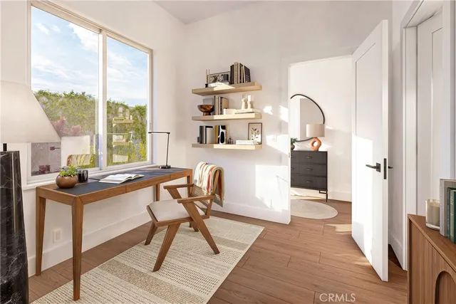 a view of a workspace with furniture and a window