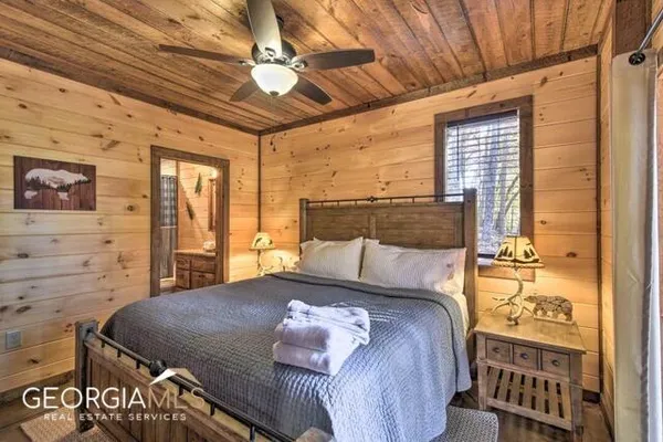a bedroom with a bed a chandelier and a window