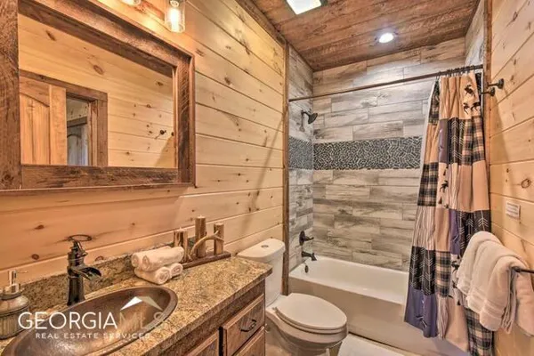 a bathroom with a granite countertop sink mirror vanity and bathtub
