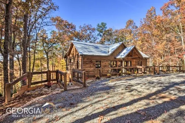 a view of a large house with a yard and wooden fence