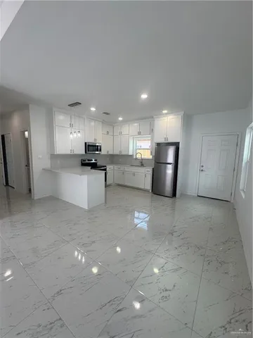 a kitchen with stainless steel appliances a refrigerator sink and cabinets