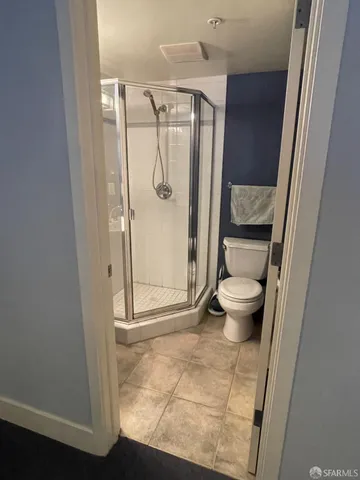 a bathroom with a glass door shower a toilet and a sink