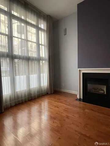 a view of an empty room with a fireplace and a window