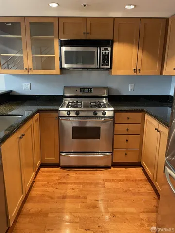 a kitchen with stainless steel appliances granite countertop a stove and a microwave