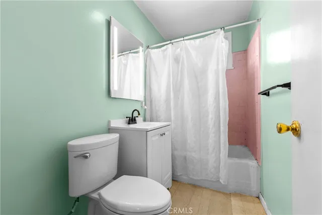 a bathroom with a sink a toilet and shower curtain