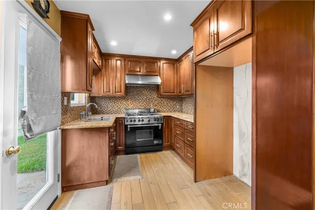 a kitchen with stainless steel appliances granite countertop a stove a sink and a refrigerator