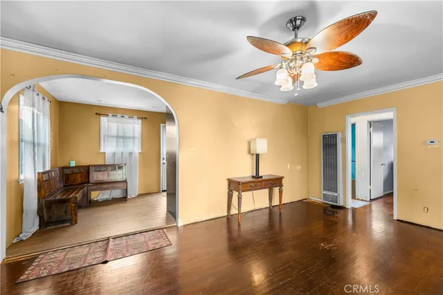 a view of a livingroom with wooden floor and a ceiling fan