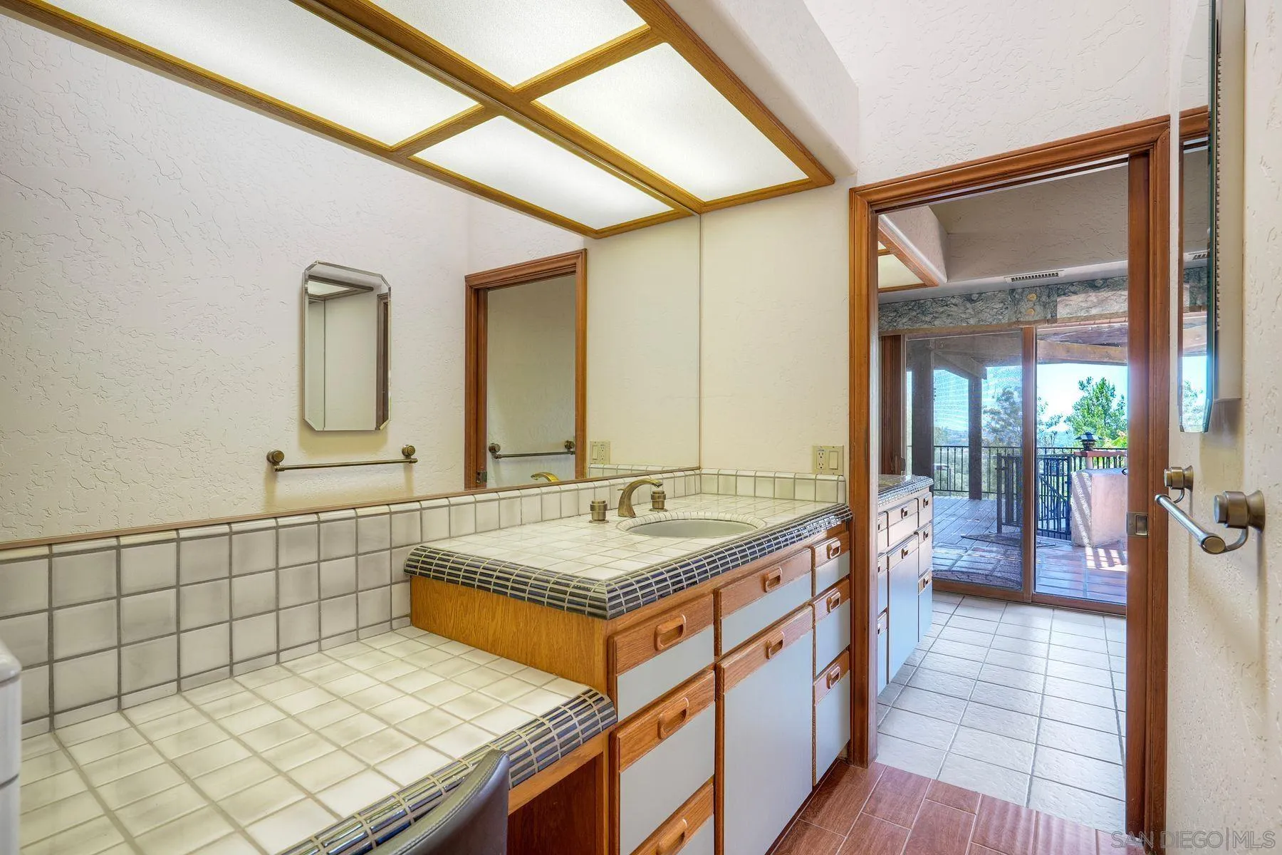 30458 Cool Valley Highlands Road Valley Center, CA 92082 - Photo 38 of 47 a bathroom with a granite countertop sink and a mirror