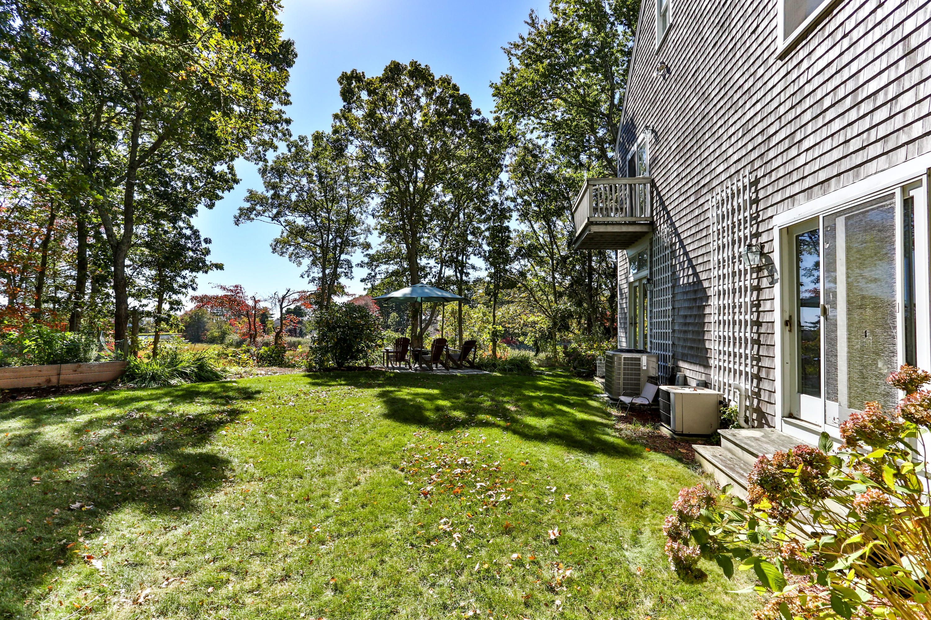 461 South Main Street Centerville, MA 02632 - Photo 46 of 52 a backyard of a house with a table and chairs