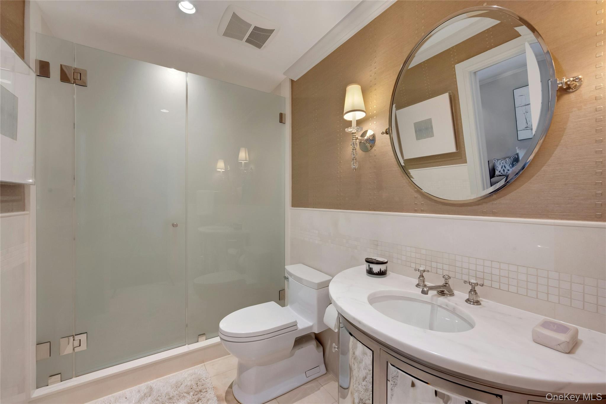 44 Brevoort Lane Rye, NY 10580 - Photo 12 of 32 Guest bath featuring a marble vanity, glass-enclosed shower, limestone finishes and refined designer finishes.