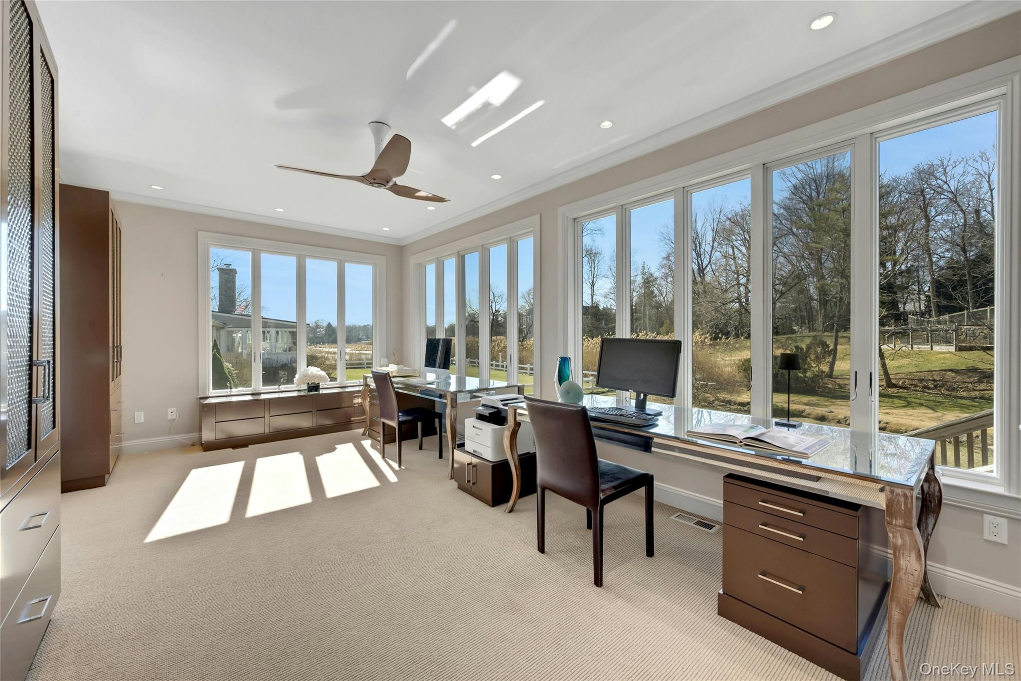 44 Brevoort Lane Rye, NY 10580 - Photo 6 of 32 Where work meets inspiration. Walls of glass frame breathtaking views, and the sunsets here are simply draw dropping. Currently a sun drenched office with endless possibilities. Would also make an extraordinary dining room as it is off the kitchen. Barn doors allow for secluded privacy. Georgio designed built-ins