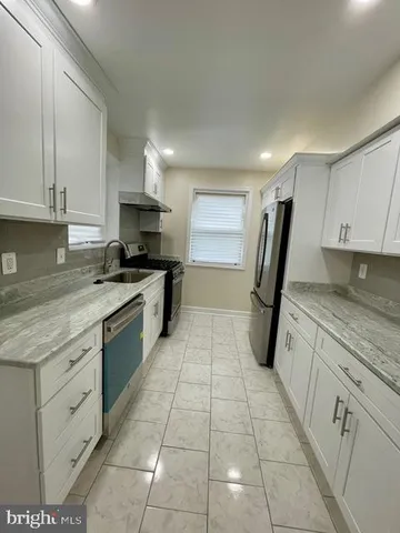 a kitchen with a sink a stove top oven and cabinets