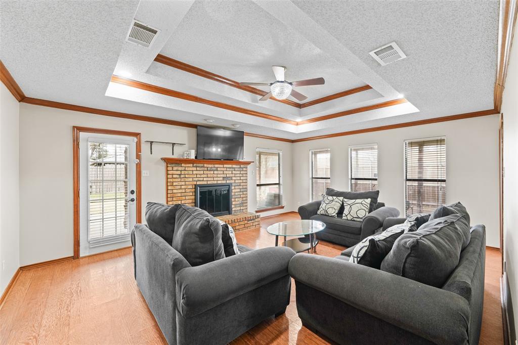 708 Azalea Drive Forney, TX 75126 - Photo 3 of 18 a living room with furniture a fireplace and a large window