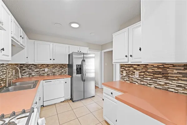 a kitchen with white cabinets and white appliances