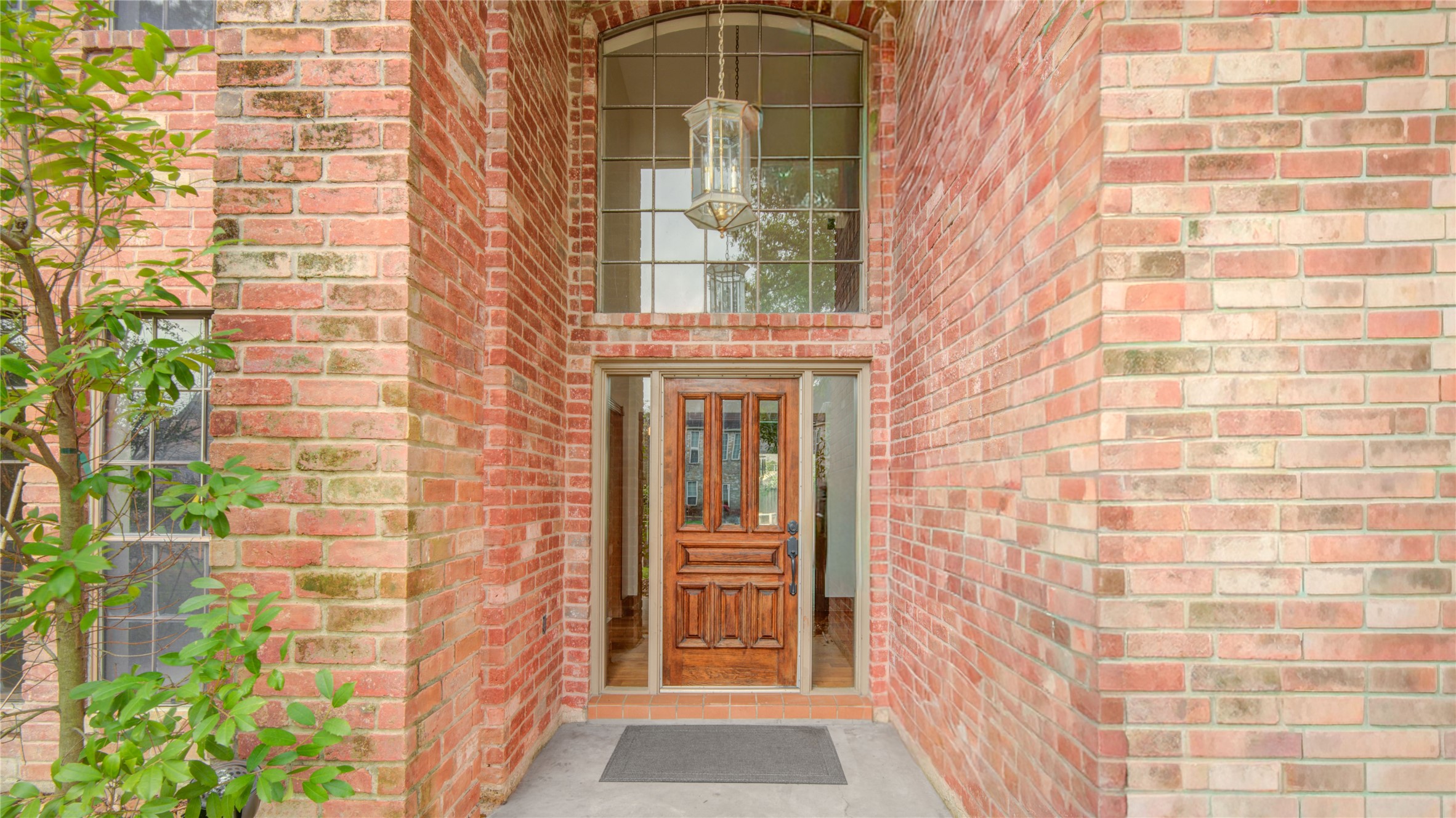 8412 Hidden Trail Lane Spring, TX 77379 - Photo 4 of 43 The covered front entry features classic brick architecture, a grand two-story window, and a warm wood front door that creates an elegant first impression.