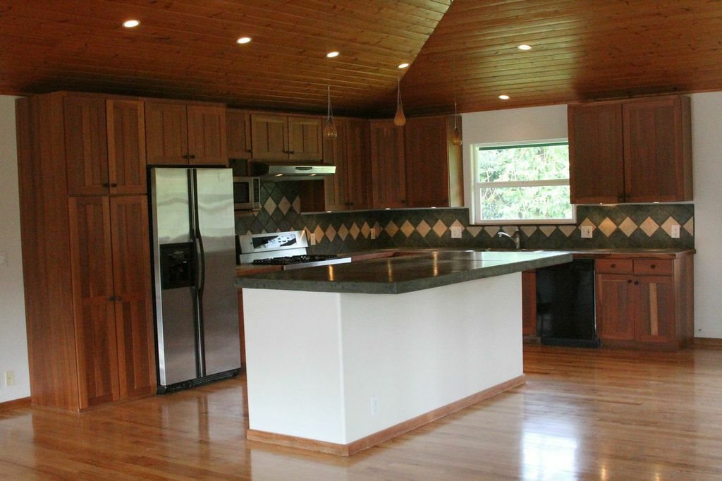 851 Peahi Road Haiku, HI 96708 - Photo 18 of 30 a kitchen with stainless steel appliances granite countertop a refrigerator a sink a stove a microwave and wooden floors