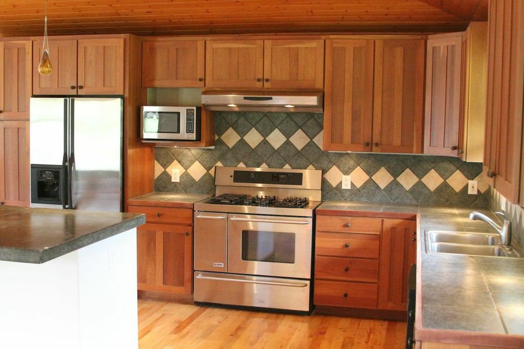 851 Peahi Road Haiku, HI 96708 - Photo 5 of 30 a kitchen with stainless steel appliances granite countertop a stove and a microwave
