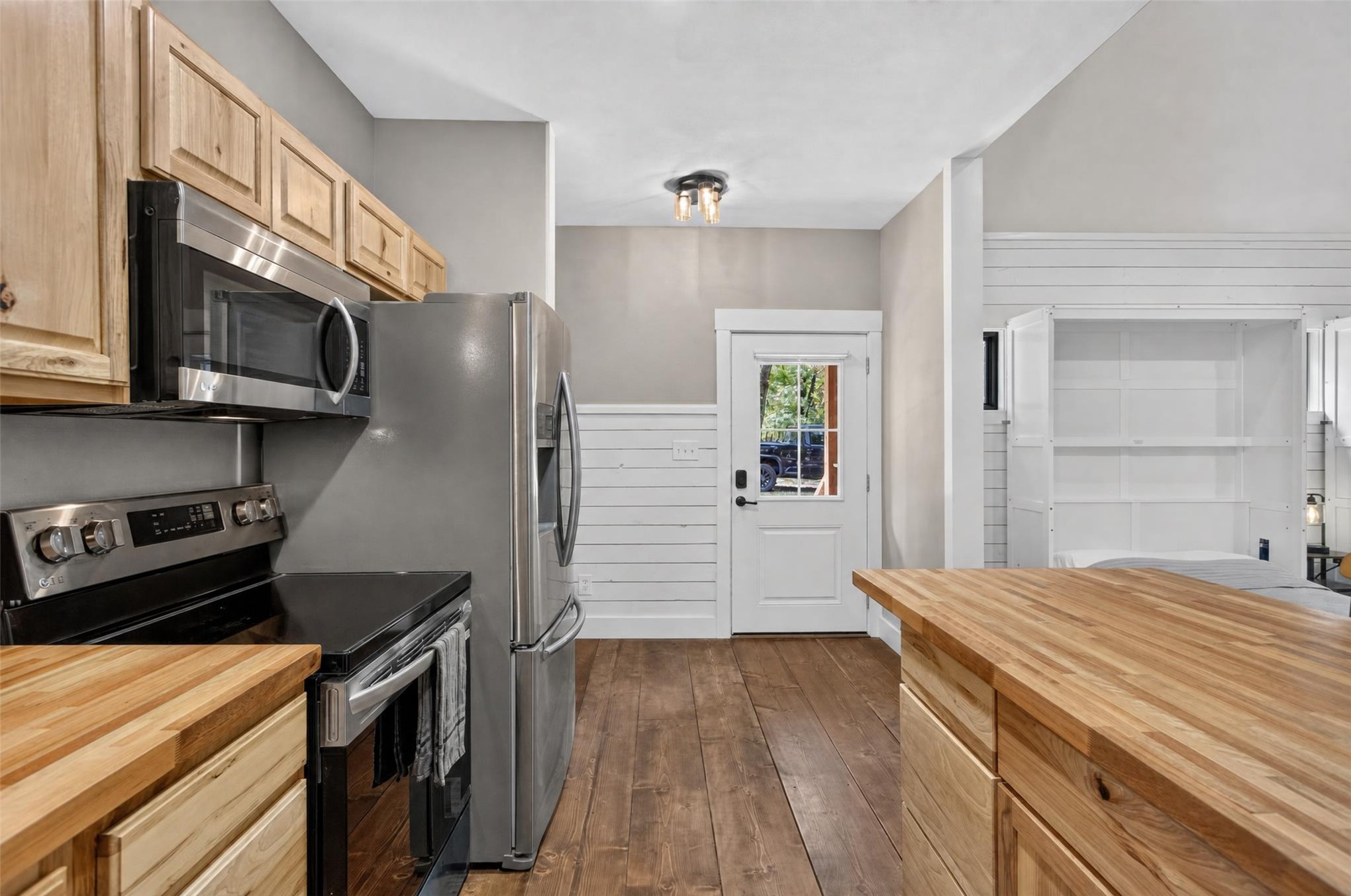 13063 East 403 Road Spavinaw, OK 74366 - Photo 5 of 25 Stainless steel appliances, wood-finish flooring, wood cabinetry, wood countertops, and a full-light exterior door