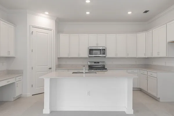 a kitchen with stainless steel appliances granite countertop white cabinets sink and stove