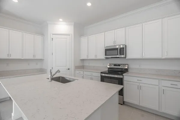 a kitchen with white cabinets and stainless steel appliances
