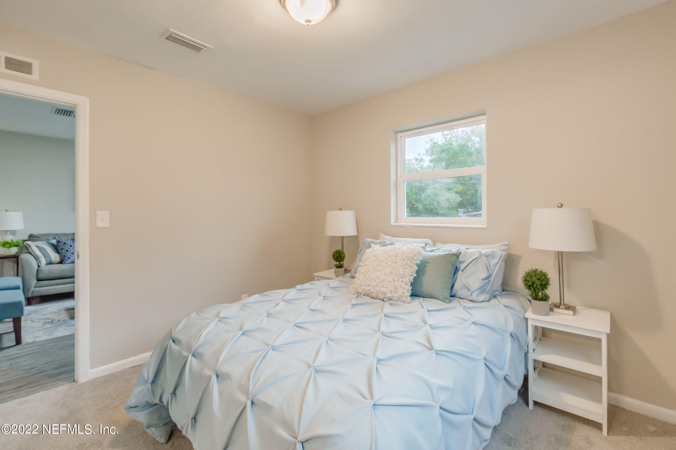 7436 Bamberg Road Jacksonville, FL 32277 - Photo 18 of 28 a bedroom with a bed and a window