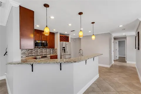 an empty room with ceiling fan and windows
