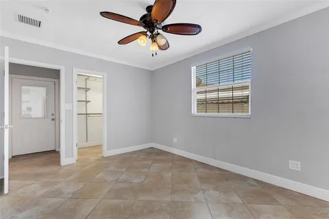 an empty room with closet and a chandelier fan