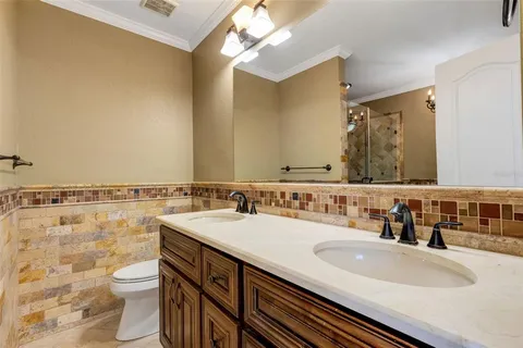 a bathroom with a granite countertop sink toilet a mirror and shower