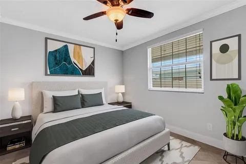 a view of an empty room with window and chandelier fan