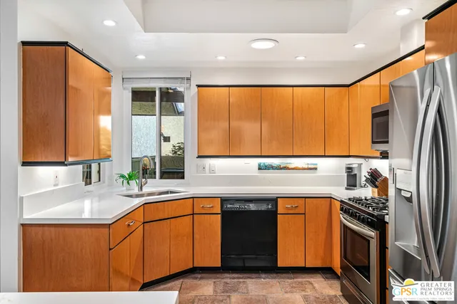a kitchen with stainless steel appliances granite countertop sink stove top oven and microwave