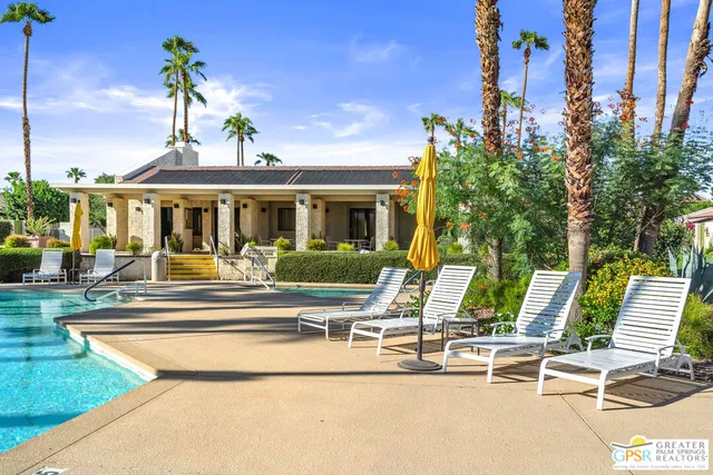 a view of a fountain in front of a house with a yard