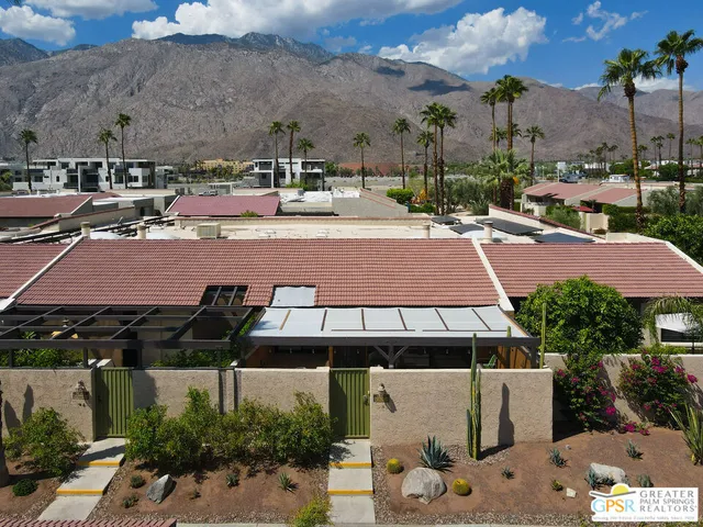 an aerial view of a house with outdoor space seating area and trees all around