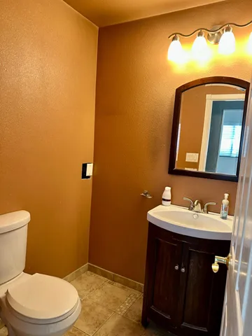 a bathroom with a toilet a sink and mirror