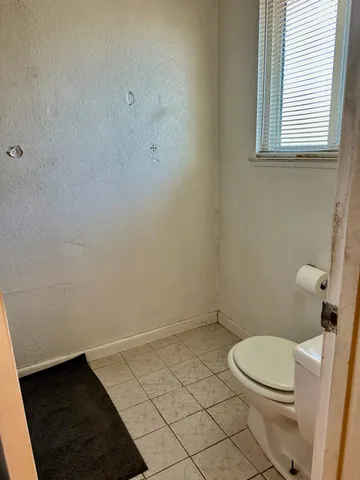 a white toilet sitting next to a window