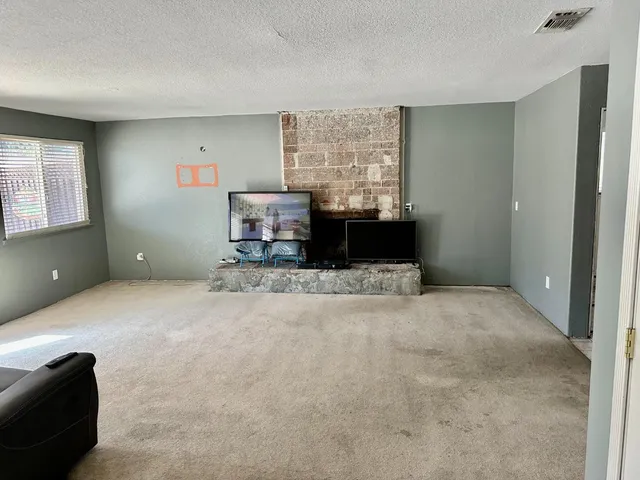 a spacious bedroom with a bed and a window