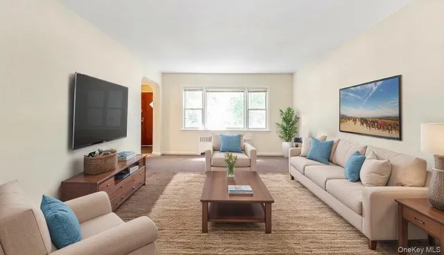 a living room with furniture wooden floor and a flat screen tv