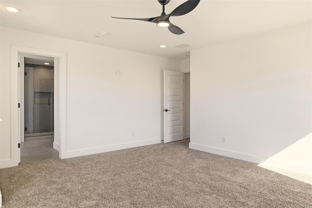 8902 Lowell Street Rowlett, TX 75089 - Photo 14 of 32 an empty room with a ceiling fan and carpet