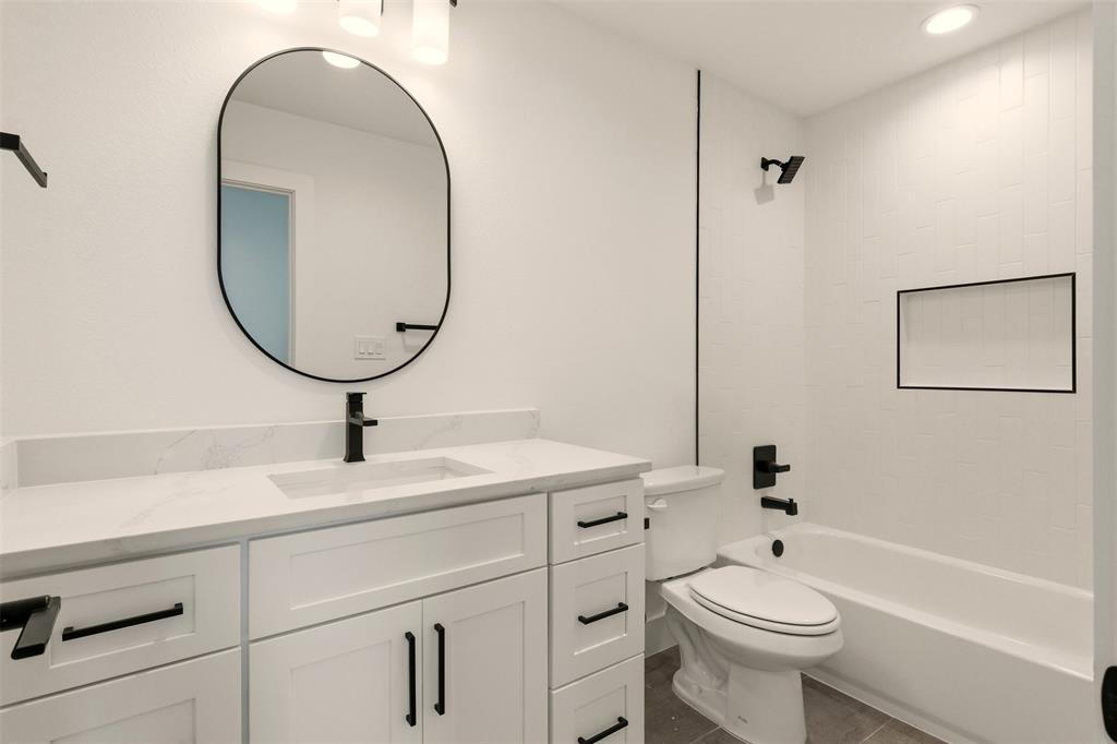 8902 Lowell Street Rowlett, TX 75089 - Photo 22 of 32 a bathroom with a toilet sink and mirror