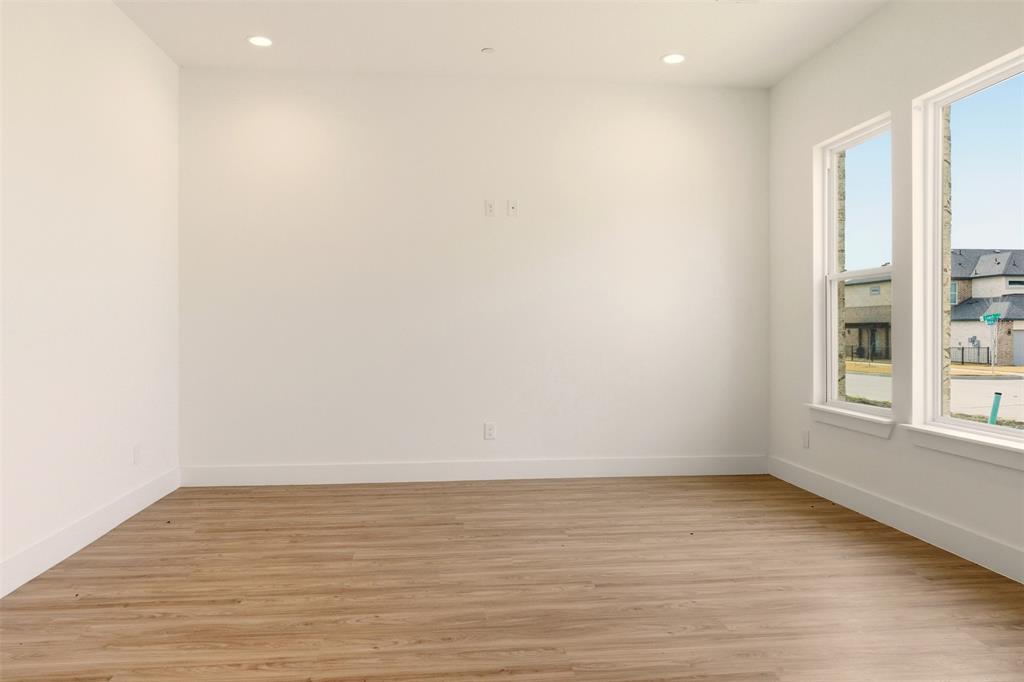 8902 Lowell Street Rowlett, TX 75089 - Photo 8 of 32 a view of an empty room with wooden floor and a window