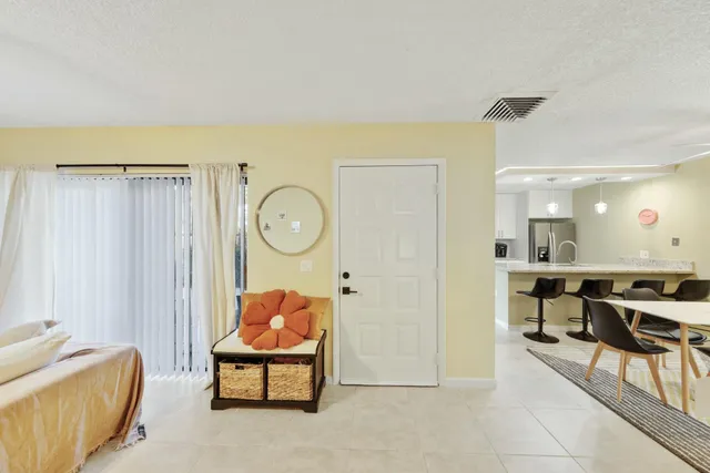 a living room with furniture a air conditioner vent and a window