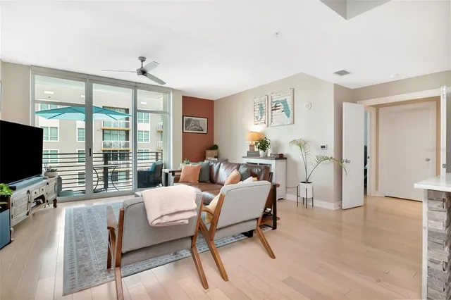 a living room with furniture a flat screen tv and a large window