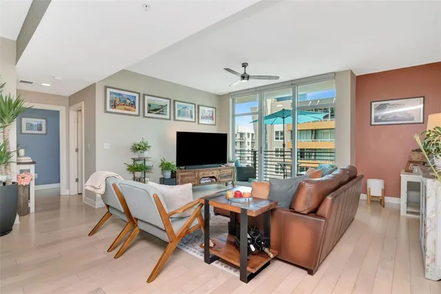 a living room with furniture a flat screen tv and a large window