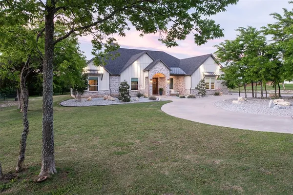 a front view of a house with a yard and trees