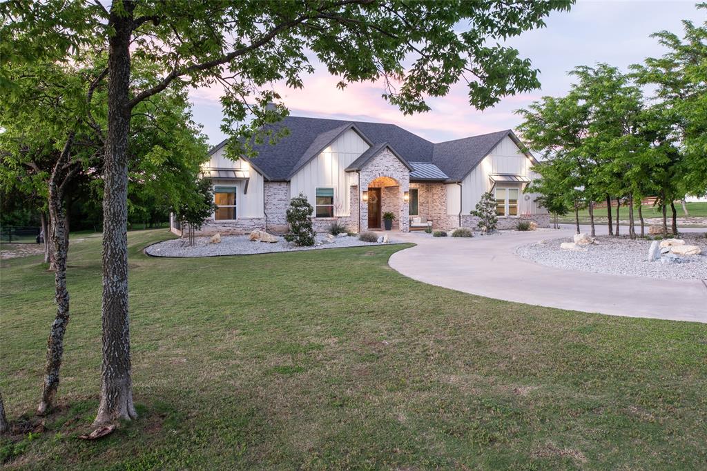 a front view of a house with a yard and trees