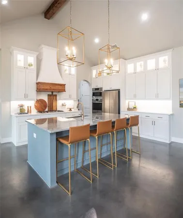 a kitchen with granite countertop a stove a sink a dining table and chairs
