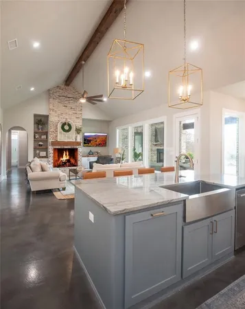 a kitchen with sink and view of living room