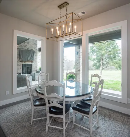 a dining room with furniture a chandelier and wooden floor