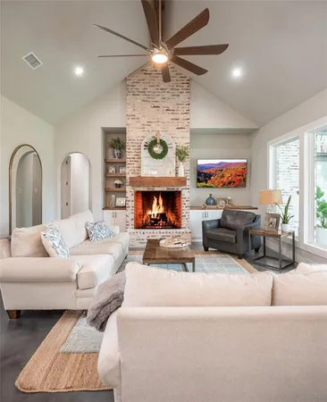 a living room with furniture fireplace and a large window