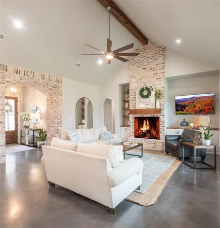 a living room with furniture a fireplace and a flat screen tv