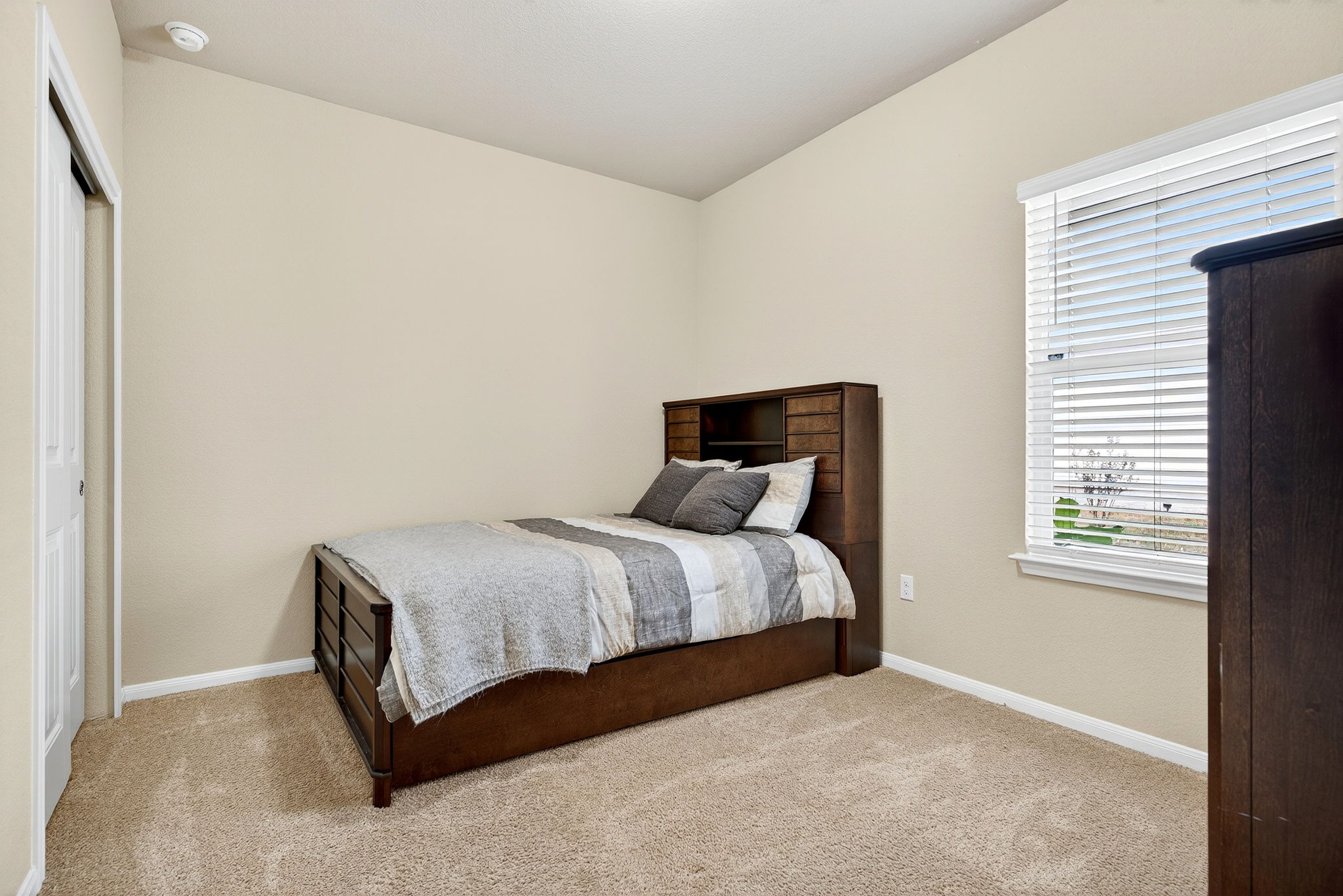 131 Coleto Creek Loop Kyle, TX 78640 - Photo 20 of 30 Bright and comfortable secondary bedroom with plush carpeting—perfect for family, guests, or a home office setup.